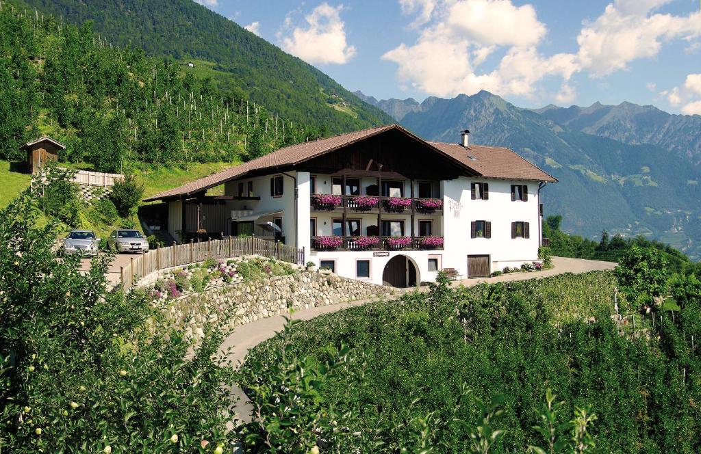 a large white house on a hill with mountains at Appartements Peilerhof in Cermes