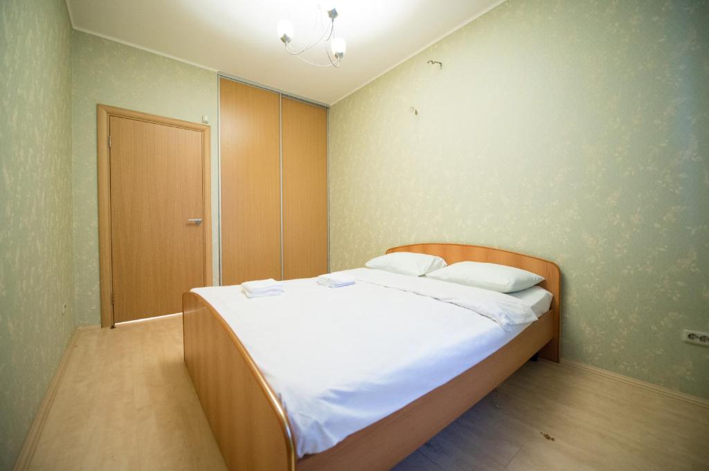 車里雅賓斯克的住宿－Five Stars on Timiryazeva 29，一间卧室配有一张带白色床单的大床
