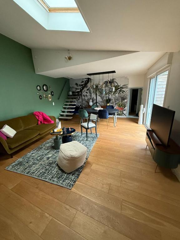 un salon avec un canapé et une table dans l'établissement Maison proche du centre, à La Rochelle