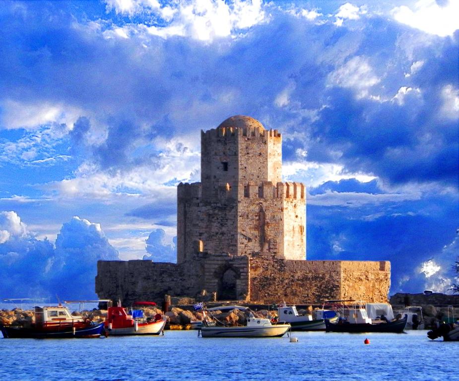 un castello in mezzo all'acqua con barche di Ulysses Hotel a Methoni