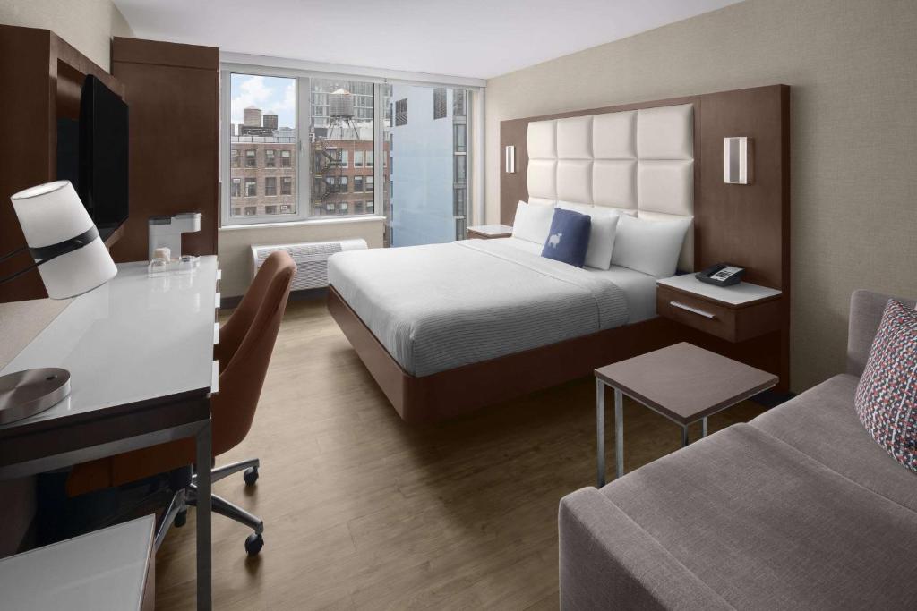 a hotel room with a bed and a desk at Cambria Hotel New York - Chelsea in New York