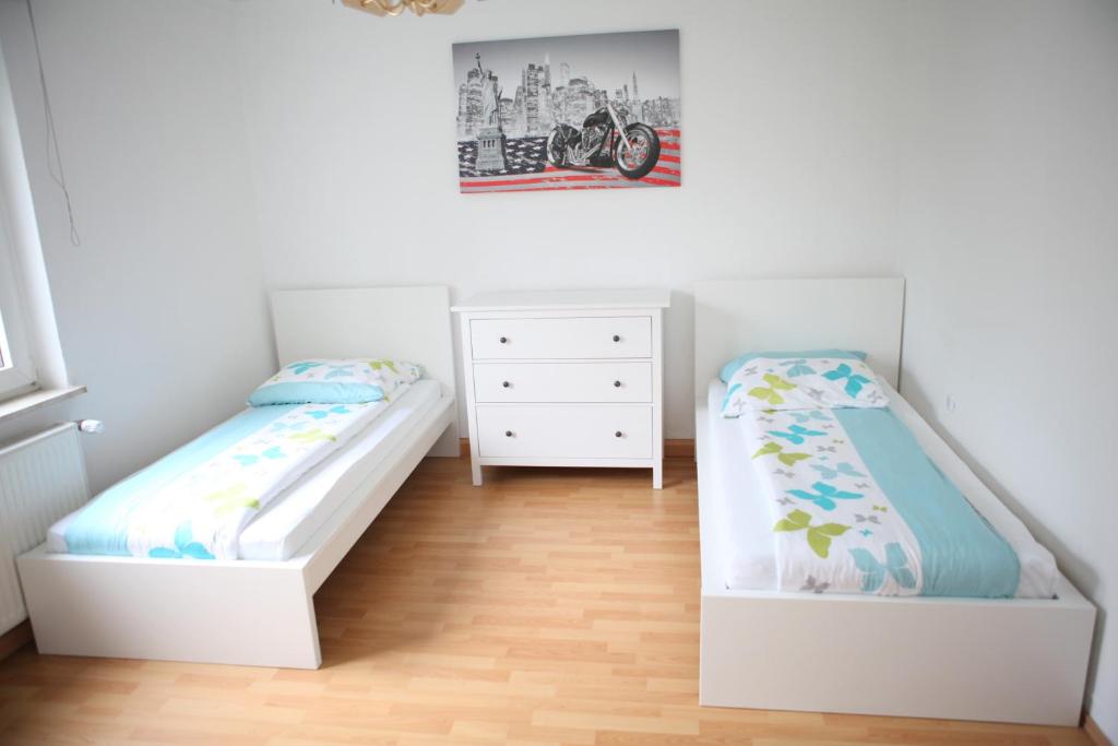 a bedroom with two beds and a dresser at White House Bochum II in Bochum