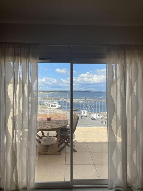 un balcon avec une table et une vue sur l'océan dans l'établissement L'ecrin de Thau, à Marseillan