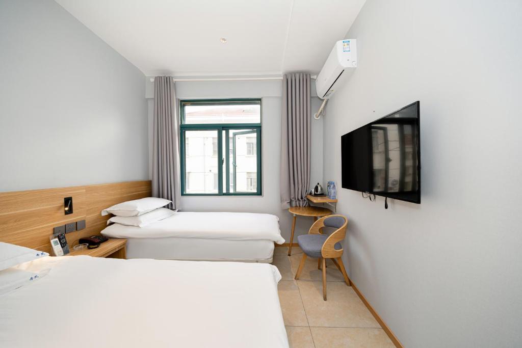 a hotel room with two beds and a tv at Dengba Inn-Fengqiao Road Subway Station Global Harbor Branch in Shanghai