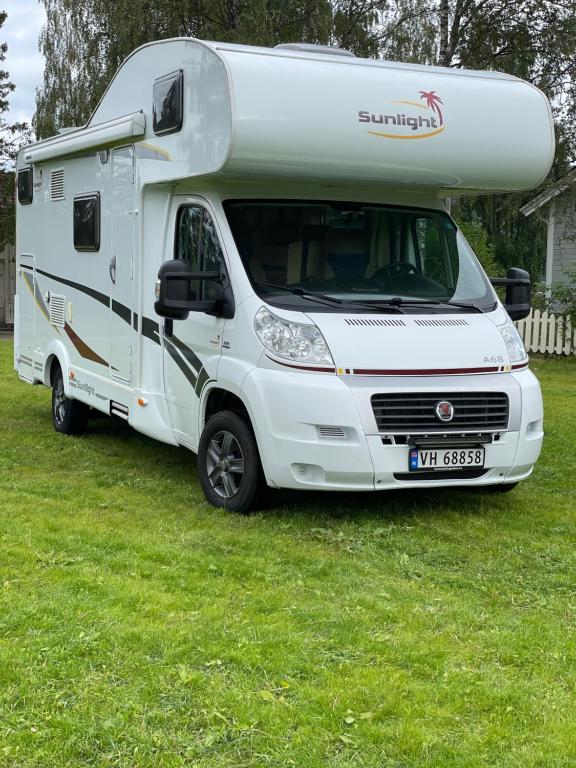 RognanにあるMotorhome in Northern Norwayの草原に置かれた白いrv