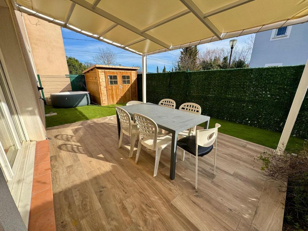 - une table et des chaises sous un parasol sur la terrasse dans l'établissement Maison 3 chambres avec jardin et spa, aux Arcs-sur-Argens