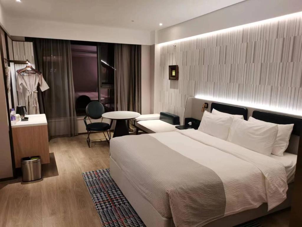 Ένα ή περισσότερα κρεβάτια σε δωμάτιο στο Wanda Moments Beijing Pinggu