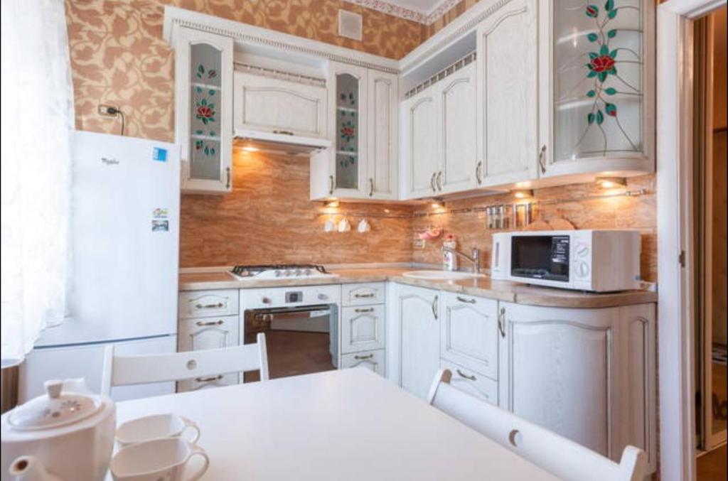 カリーニングラードにあるApartments on Leninsky Prospekt 67のキッチン(白いキャビネット、テーブル、電子レンジ付)