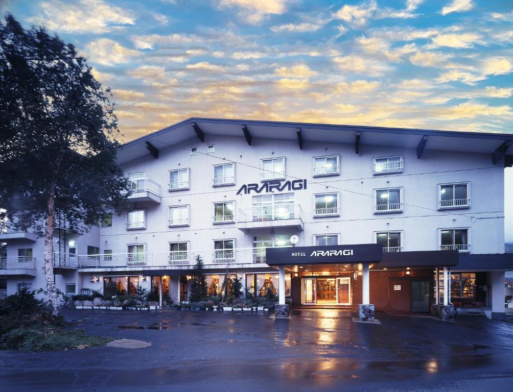 ein großes weißes Hotel mit einem Gebäude in der Unterkunft Hotel Araragi in Yamanouchi