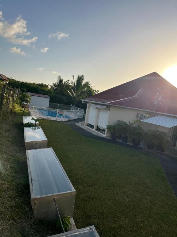 a yard with a building and a tennis court at Bungalow Sainte-Anne in Sainte-Anne