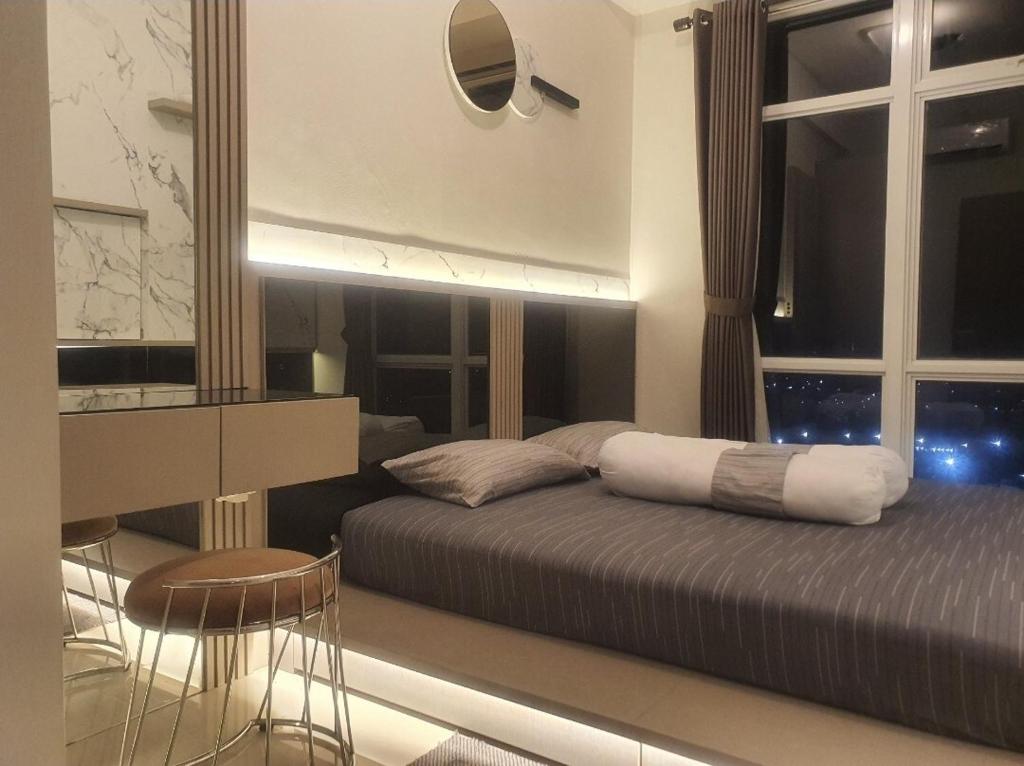 ein Schlafzimmer mit einem Bett und einem Tisch und Stühlen in der Unterkunft Beautifull Vasanta Innopark Apartment 1BR -MM 2100 Cikarang Bekasi in Jarakasta