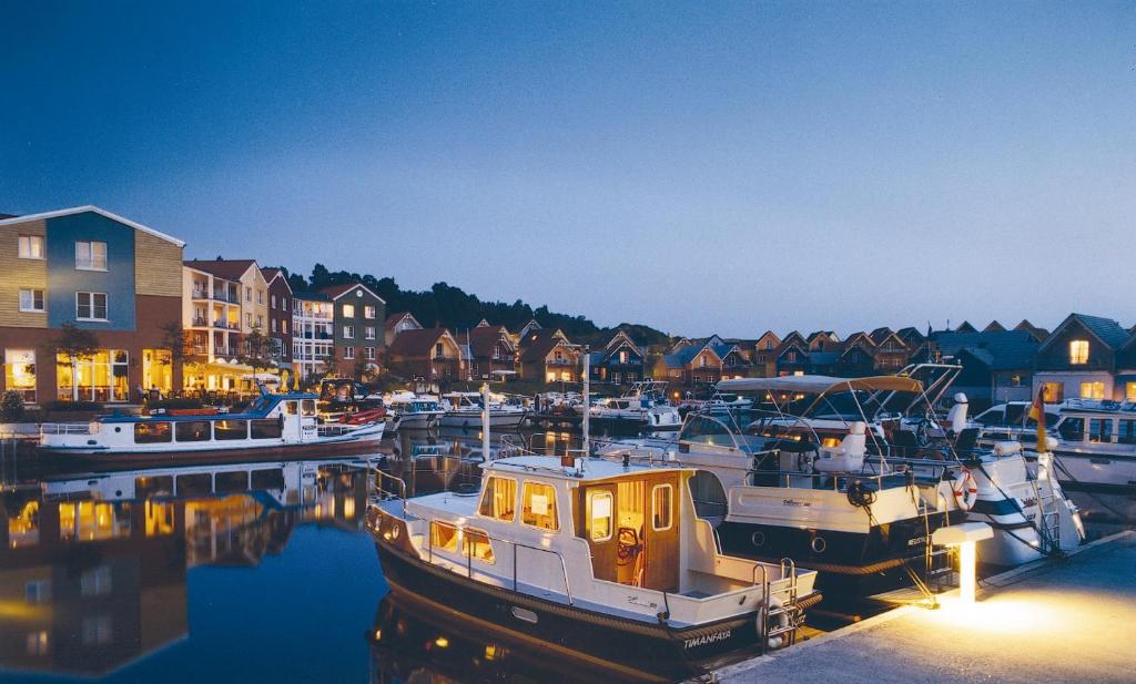 a group of boats docked in a marina at night at Precise Resort Marina Wolfsbruch - Familienapartments in Rheinsberg