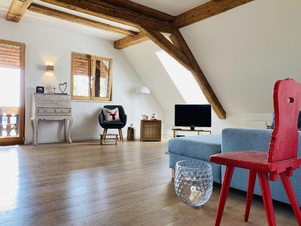 a living room with a blue couch and a red chair at Ferienwohnung Haus Alpenblick in Lenzkirch