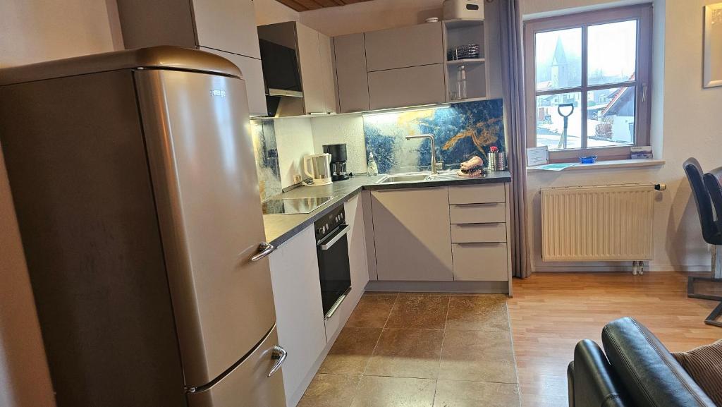 a kitchen with a stainless steel refrigerator and white cabinets at Jungholz Erlebnis in Jungholz