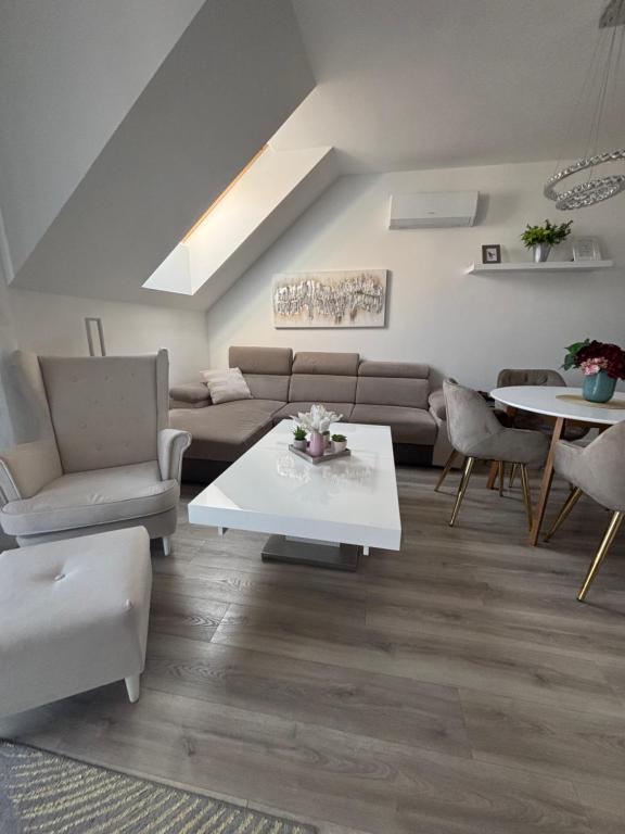 a living room with a couch and a table and chairs at LaMira 2,3 Apartments in Hajdúszoboszló