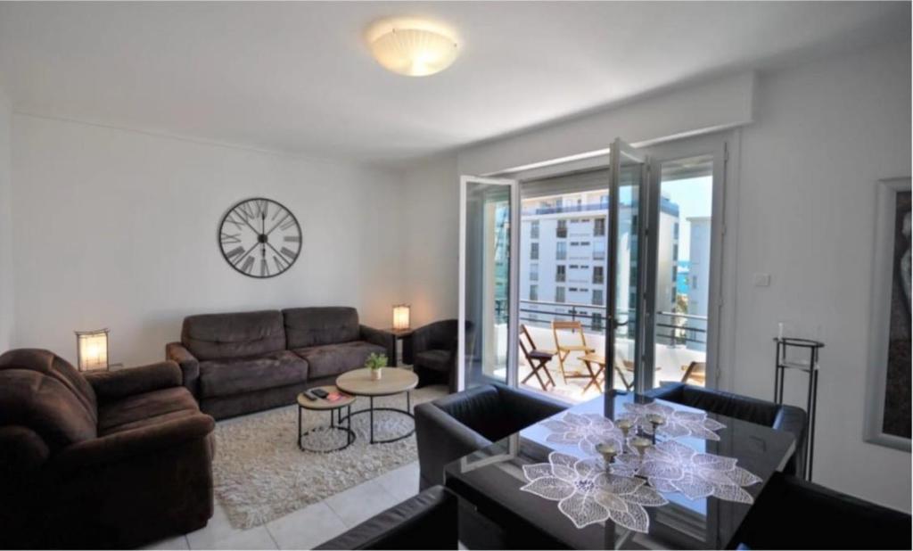 - un salon avec des canapés et une horloge murale dans l'établissement Stylish 3P, 2 pas la Croisette, à Cannes