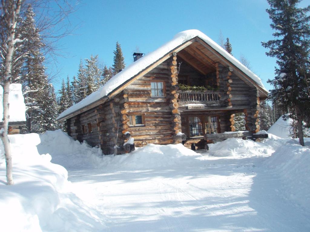 a log cabin is covered in snow at Ylläshilla Cottage in Äkäslompolo