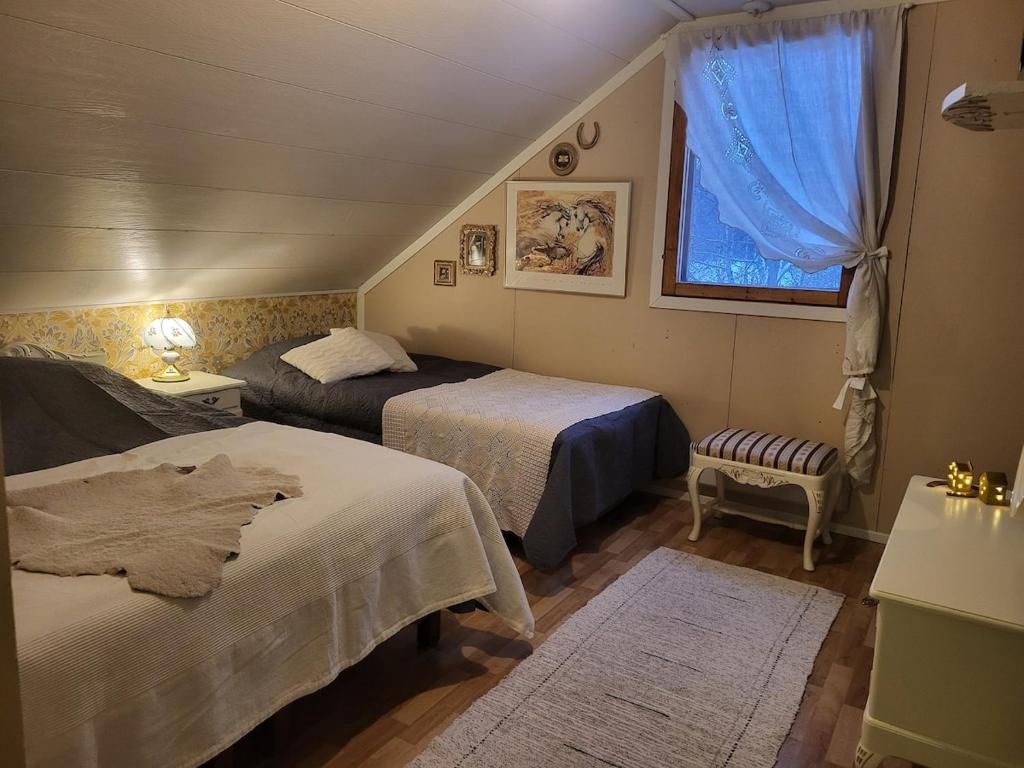 a small bedroom with two beds and a window at Ainola Arctic Hillside in Rovaniemi