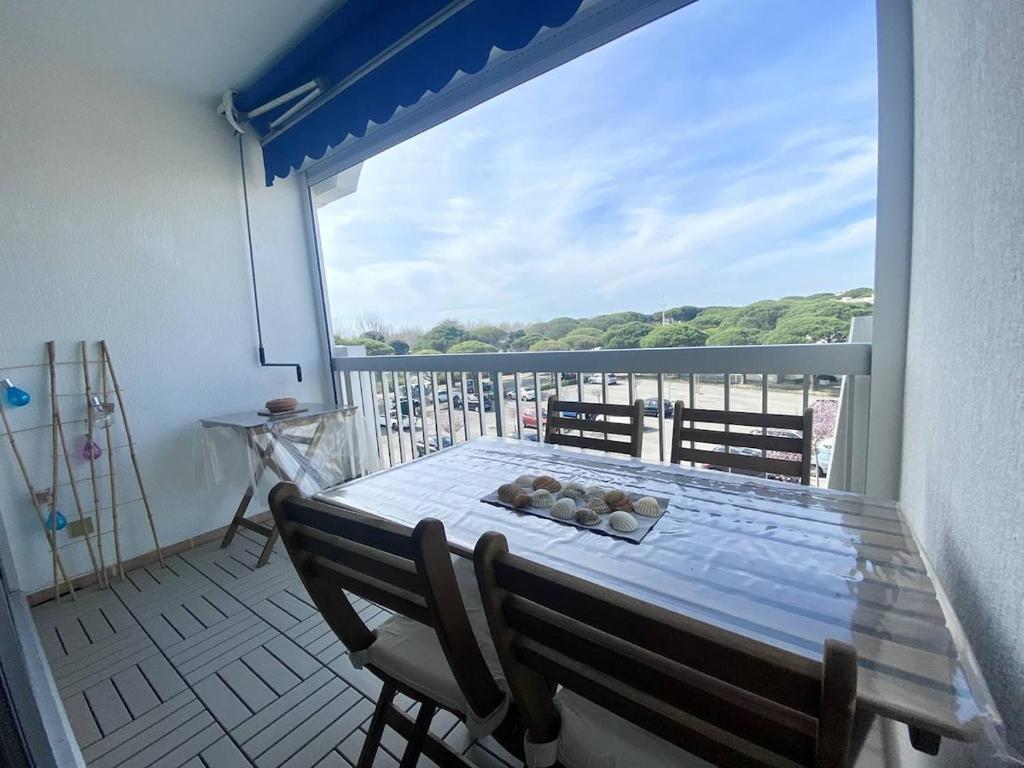 une table et des chaises sur un balcon avec vue dans l'établissement PORT CAMARGUE - CHARMANT STUDIO CLIMATISE POUR 4 PERSONNES AVEC TERRASSE + PARKING, au Grau-du-Roi