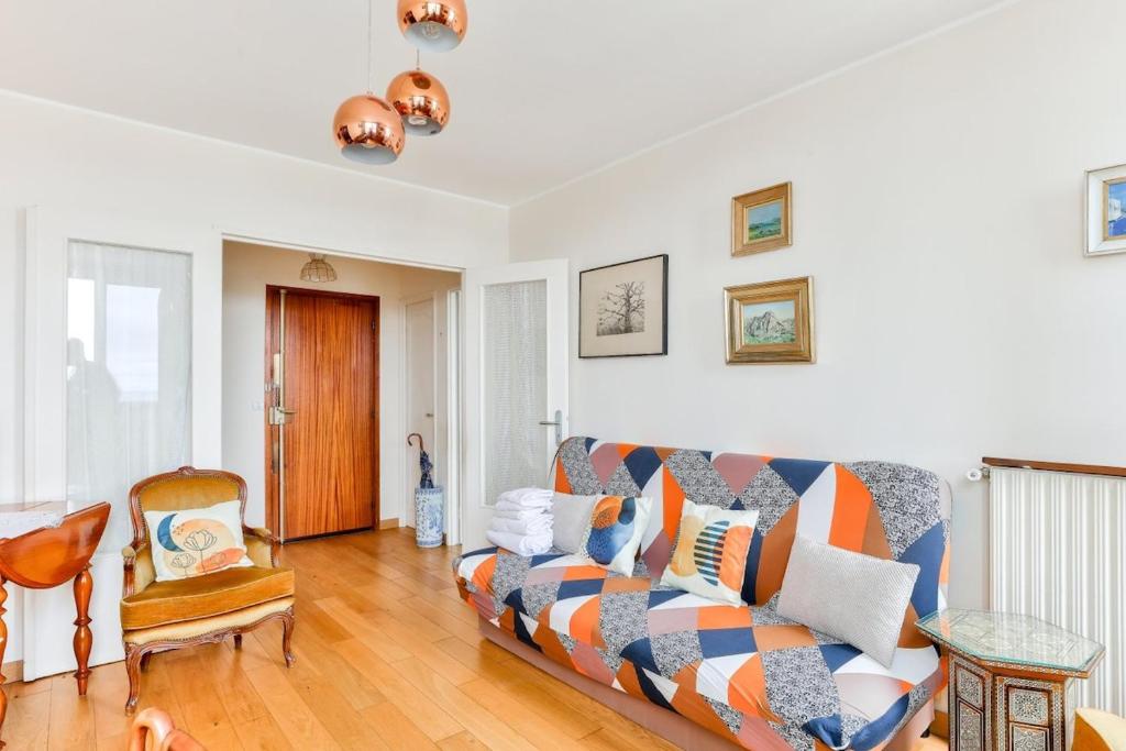 un salon avec un canapé et une chaise dans l'établissement 1BR Flat view on Eiffel Tower and Sacré-Coeur, à Paris