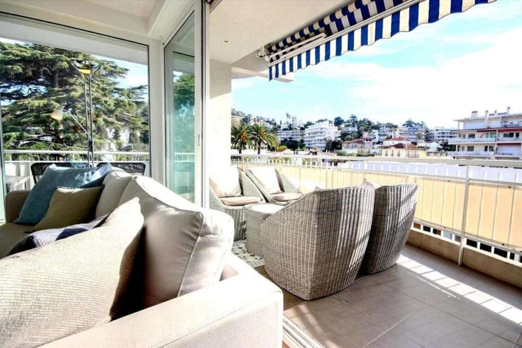 Elle comprend un balcon doté d'un mobilier blanc et d'une grande fenêtre. dans l'établissement Ideally located between the sea and Rue d'Antibes, à Cannes