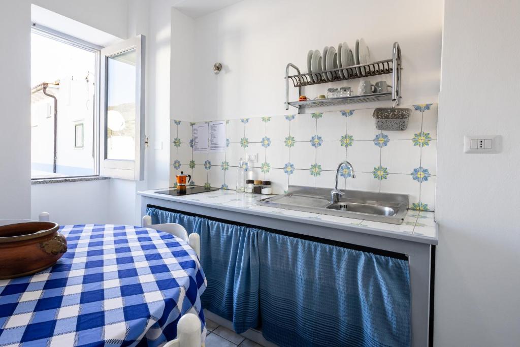 a small kitchen with a sink and a table at Lo Nardo Accommodation in Lipari