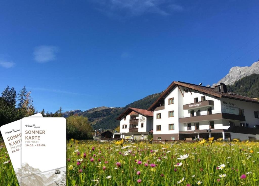 a building with a sign in a field of flowers at Haus Zangerl inkl Sommer Card Premium in Sankt Anton am Arlberg