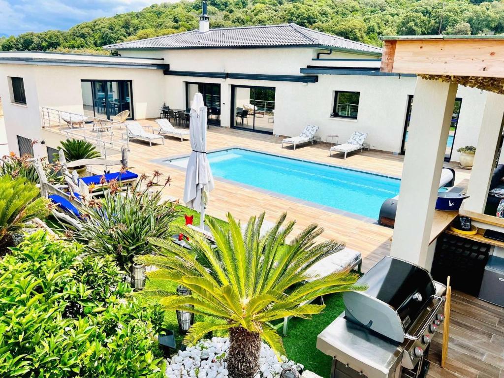 une cour arrière avec une piscine et une maison dans l'établissement luxe 5 étoiles à Porticcio, vue mer, proche des plages, à Porticcio