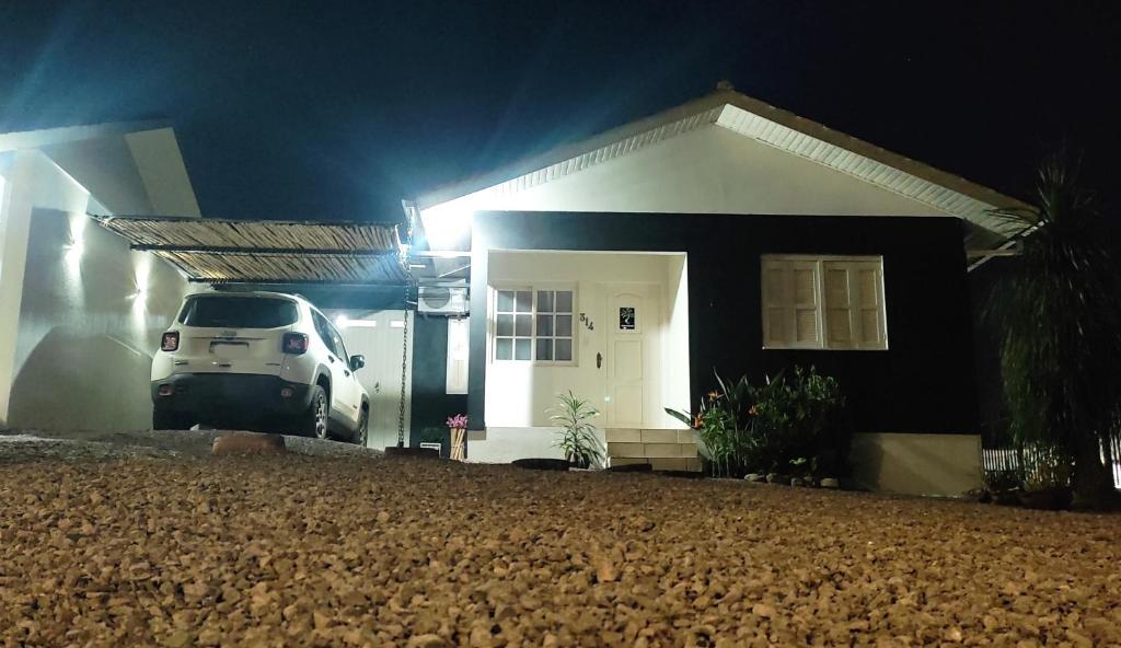 een wit busje geparkeerd voor een huis 's nachts bij Hospede-se aqui! Casa Inteira em Santa Clara do Sul in Santa Clara do Sul