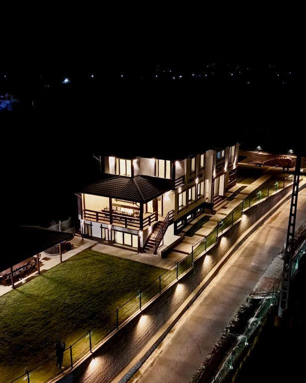a building lit up at night with lights at Conacu Lacului Brebu in Brebu Mînăstirei