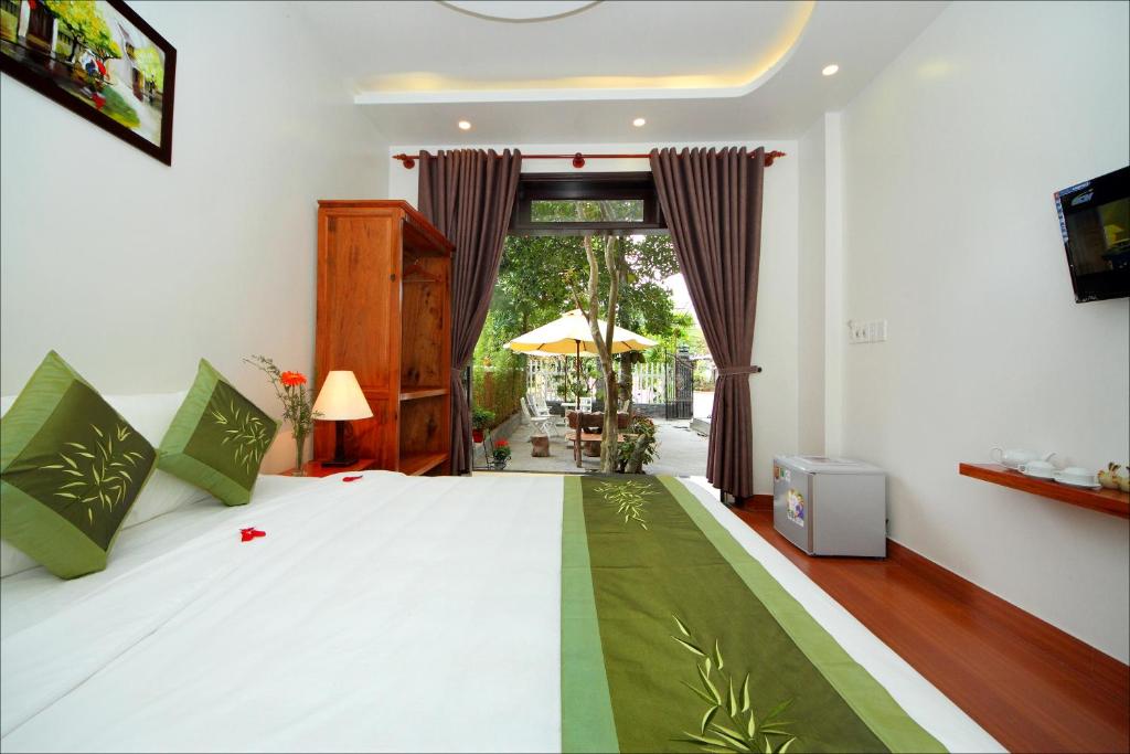 1 dormitorio con 1 cama con manta verde y blanca en Blue Lake Homestay, en Hoi An