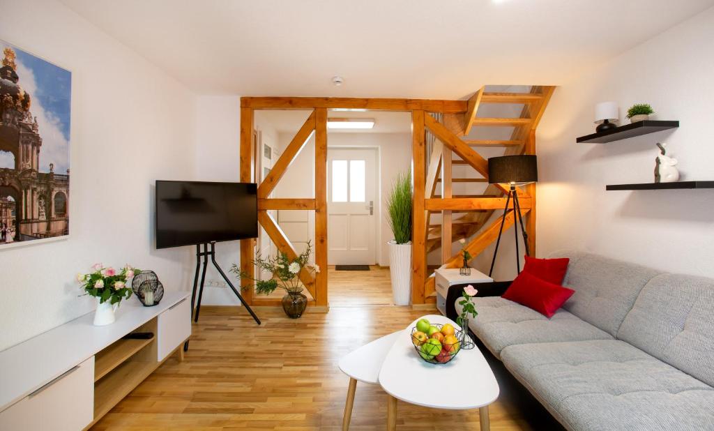 a living room with a couch and a tv at FeWo 02 Maisonette im Carre`Charlott in Pulsnitz