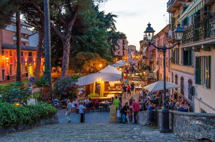 un grupo de personas caminando por una calle en una ciudad en Casa Giangarè, en Sarzana