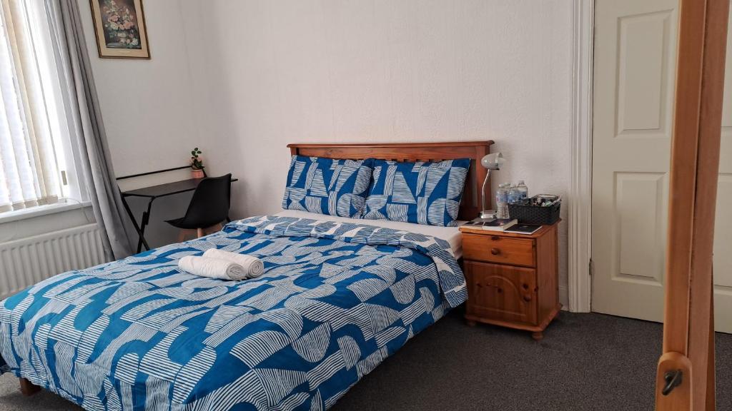 Old WalkerにあるMC Suitesのベッドルーム1室(青と白の掛け布団付きのベッド1台付)