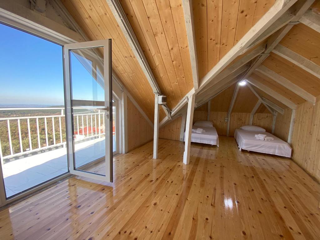 Habitación en el ático con 2 camas y ventana grande. en Meti guest house wooden room, en Krujë