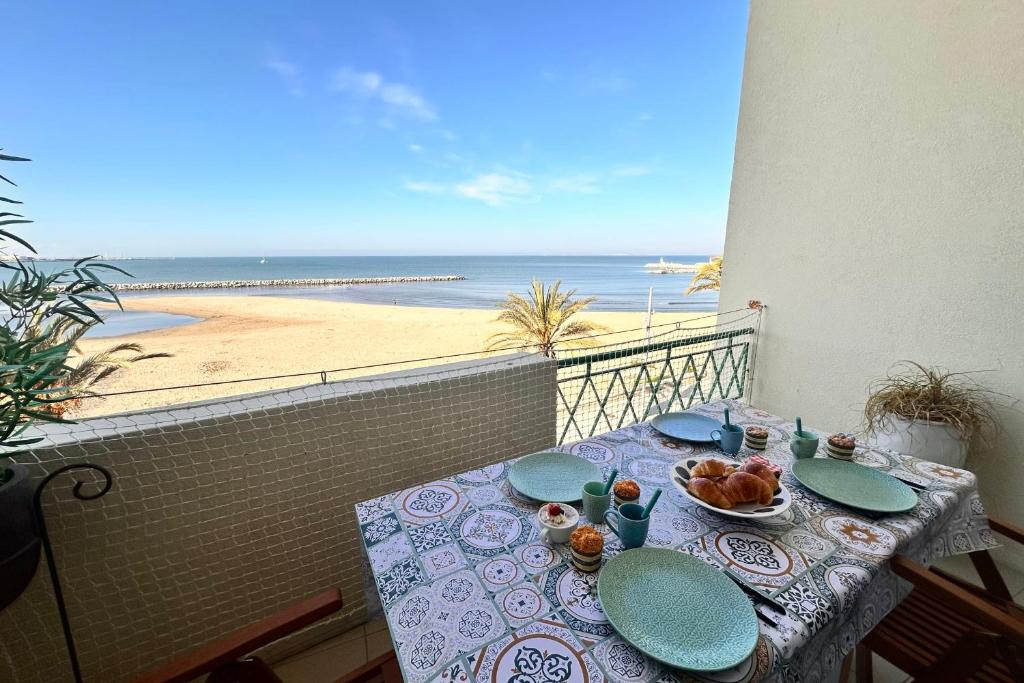 une table sur un balcon avec vue sur la plage dans l'établissement La Croix du Sud 4 - Appartement en duplex Vue Mer 1ère ligne avec terrasse, au Grau-du-Roi