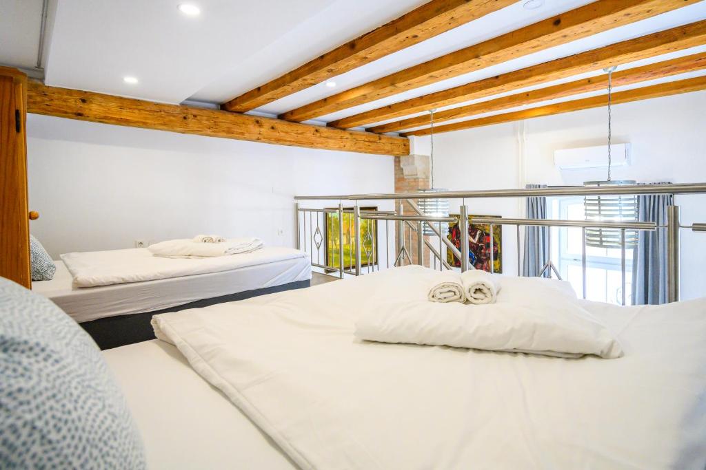 a bedroom with two beds and a large window at THE LOFT Apartments in Ljubljana