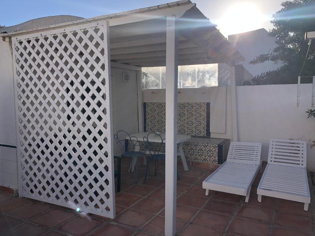 a white pergola with a table and chairs on a patio at RESIDENCE DAR YASMINa in Mezraya