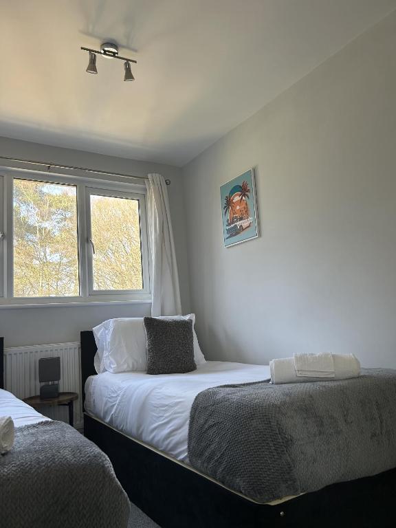a bedroom with two beds and a window at 3 Bed House Close to Gatwick in Crawley