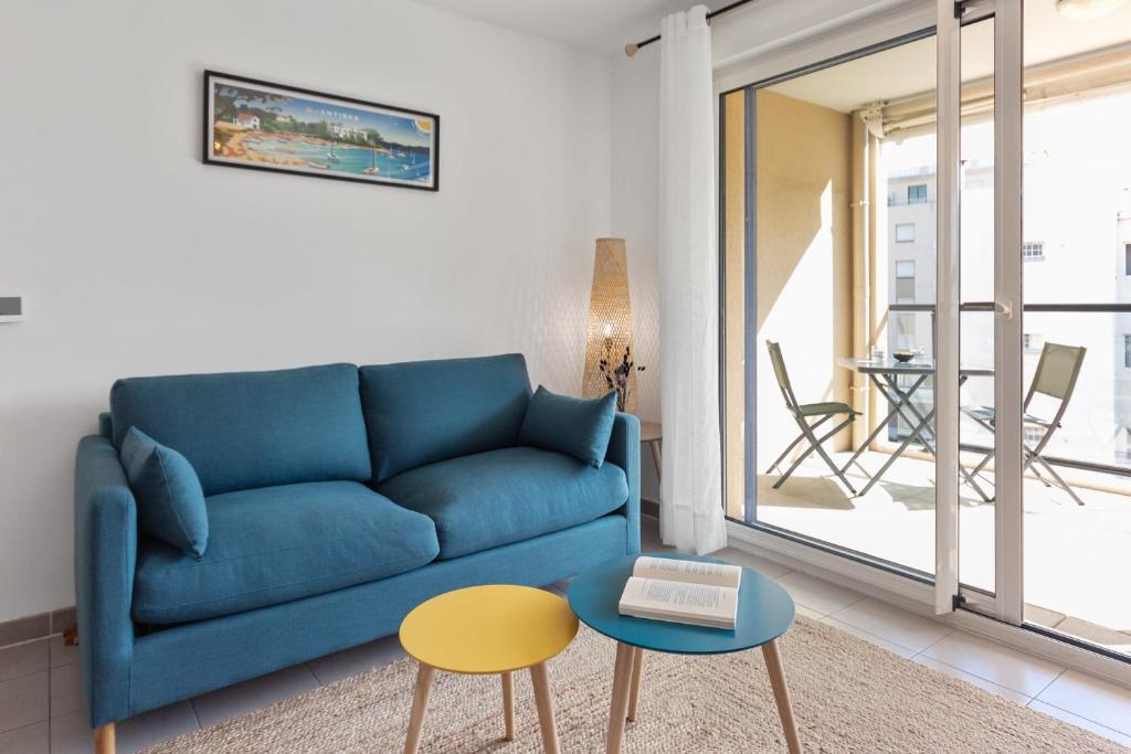 un soggiorno con un divano blu e un tavolo di L'Eden - Quiet - Parking - WIFI - Beach a Antibes