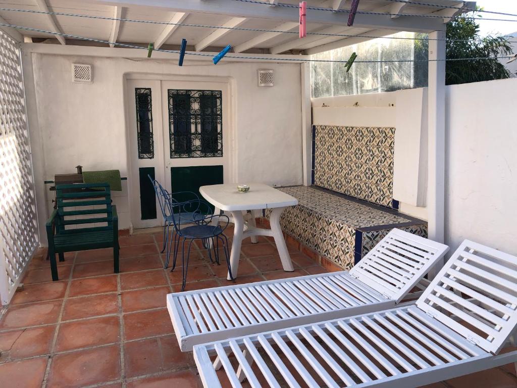 a patio with two white chairs and a table at RESIDENCE DAR YASMINa in Mezraya