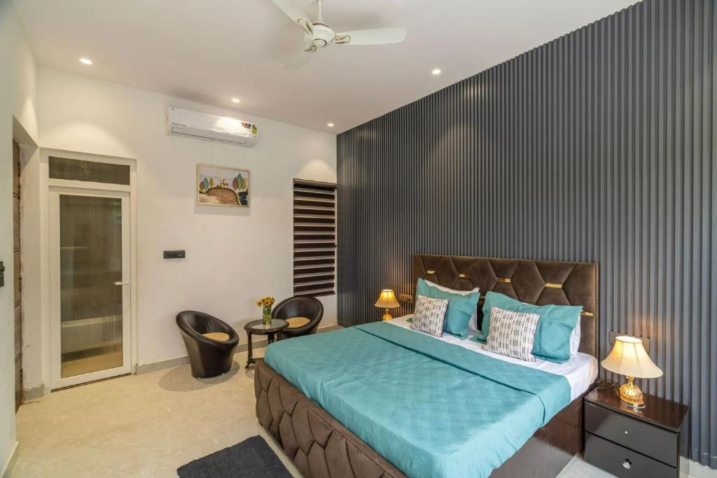 una camera da letto con letto con lenzuola e sedie blu di Bloom Haven by Madaan a Faridabad