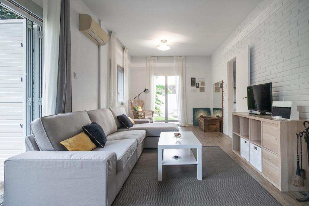 Una sala de estar con un sofá y un televisor. en Marina beach Castelldefels, en Castelldefels