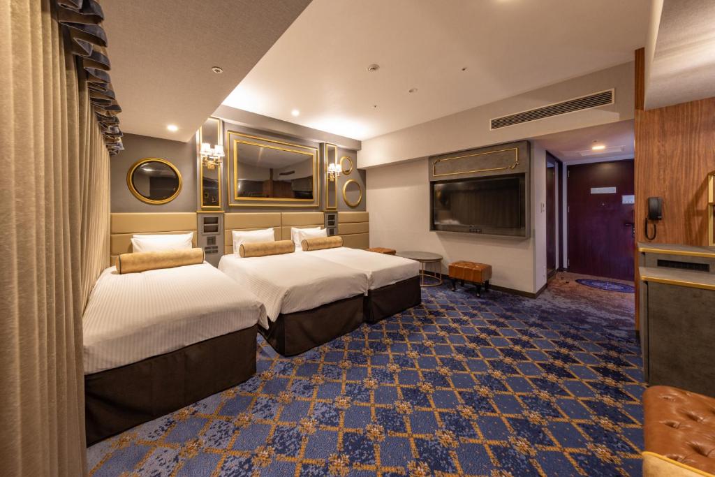 a hotel room with two beds and a television at Hotel Keihan Universal Tower in Osaka