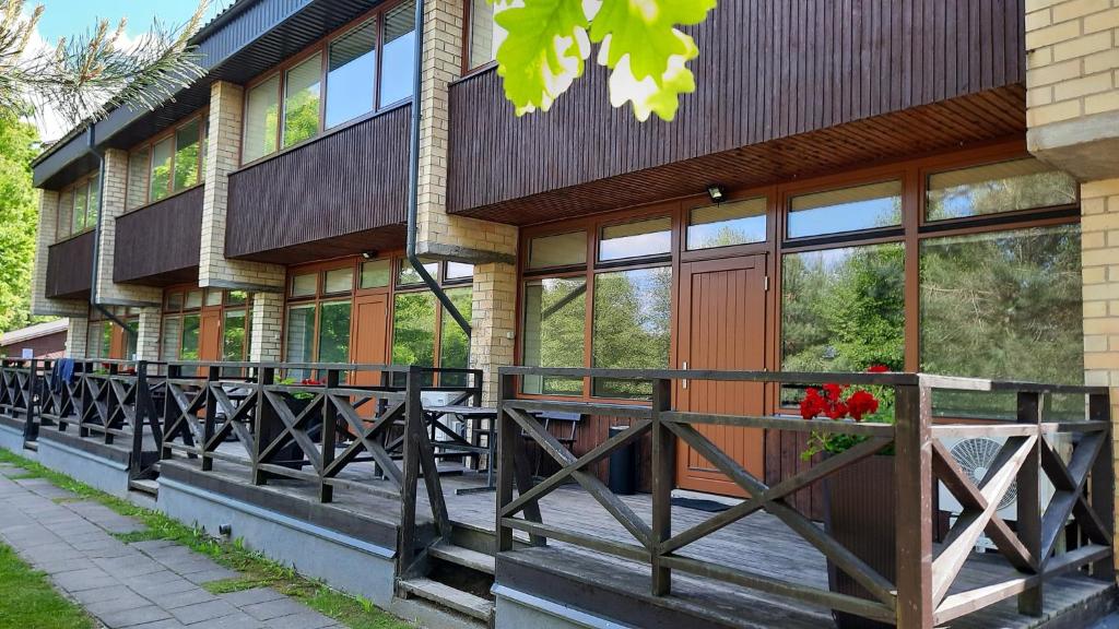 a building with a porch with flowers in a window at Kambarys Šiaurėje in Kaltanėnai