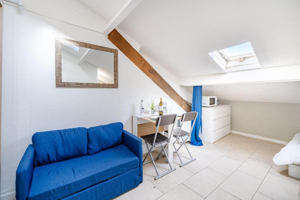 un salon avec un canapé bleu et une table dans l'établissement Cosy studio proche Gare de Nice, à Nice