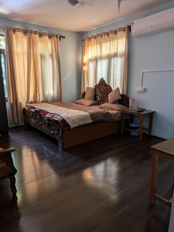 a bedroom with a large bed with curtains and a table at John's palace in Srinagar