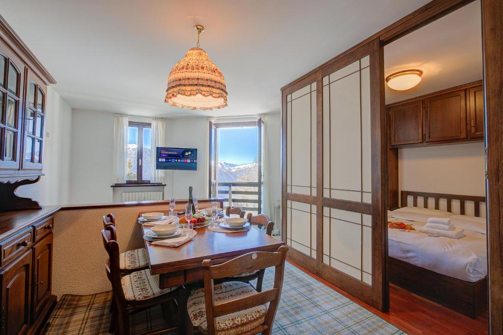 a kitchen and dining room with a table and a bed at Appartamento Principino 24 Ski in Ski out - Happy Rentals in Sestriere