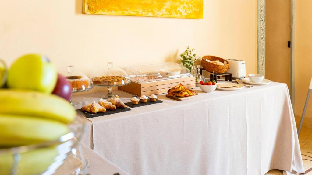 un tavolo con sopra del cibo e una tovaglia bianca di Palazzo Insula a Gallipoli