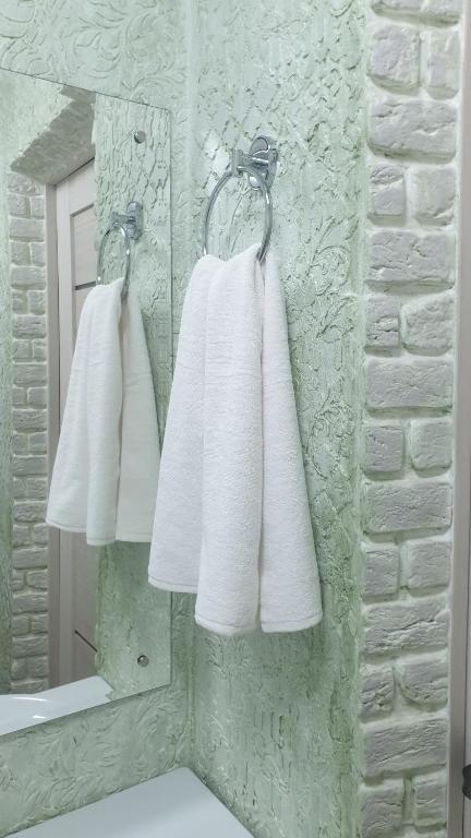 bagno con asciugamani bianchi appesi di fronte a uno specchio di Джамбула 177 a Kökşetaw